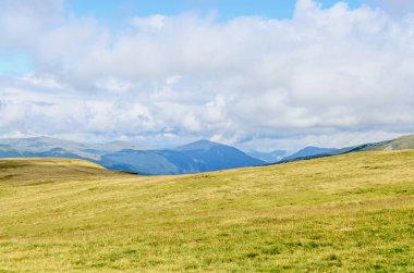 Bulutlar, yeşil çim ve kayalar ile hills Parang dağlarda