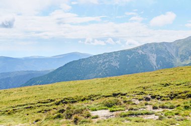Bulutlar, yeşil çim ve kayalar ile hills Parang dağlarda