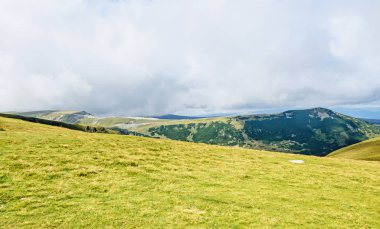 Bulutlar, yeşil çim ve kayalar ile hills Parang dağlarda