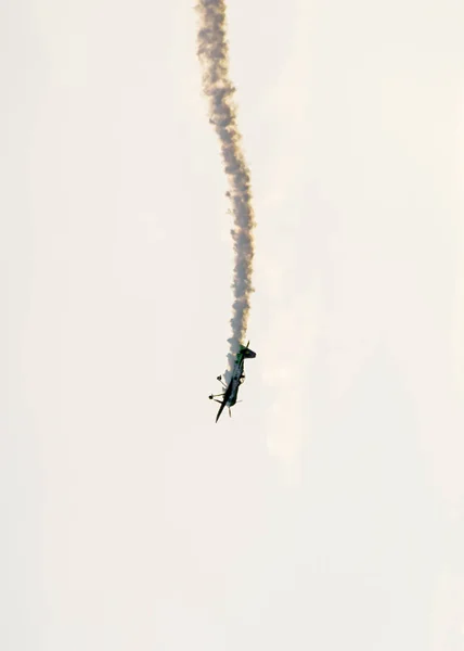 Літак з кольоровим слідовим димом, що летить у небі блакитних хмар — стокове фото