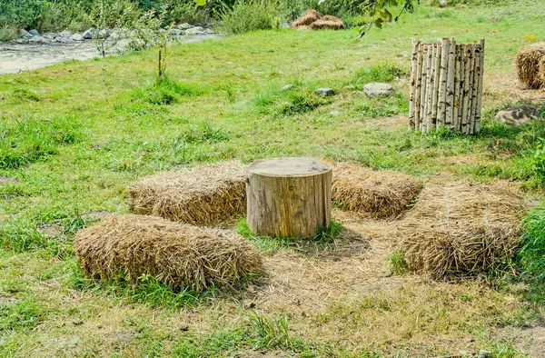 Camp extérieur avec table en bois rond et chaises en paille . — Photo