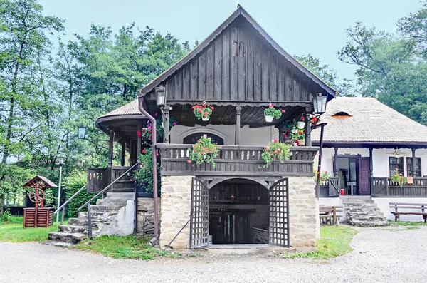 Maison traditionnelle roumaine avec balcon en bois, fleurs de géranium — Photo