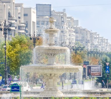 Mağazalar, trafik arabaları, turistler ile kare 
