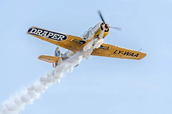 Aerobatic flygplan piloter utbildning i himlen över staden. Färgade flygplan med spår rök, airbandits, aeroshow — Stockfoto
