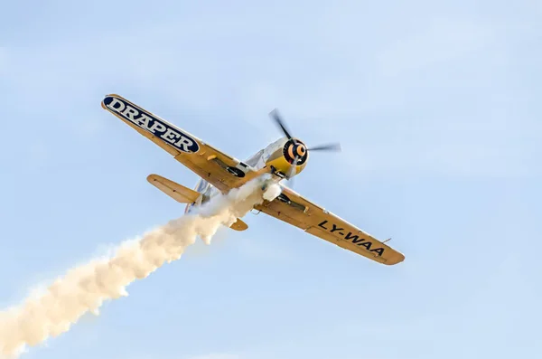 Pilotos de aviones acrobáticos entrenando en el cielo de la ciudad. Avión de color con rastro de humo, airbandits, aeroshow — Foto de Stock