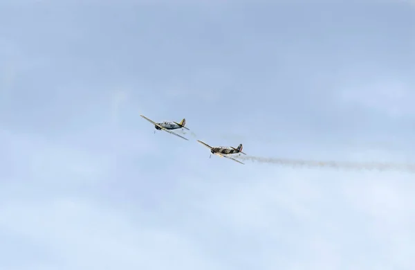 Aerobatic flygplan piloter utbildning i himlen över staden. Färgade flygplan med spår rök, airbandits, aeroshow — Stockfoto