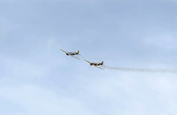 Pilotos de aviones acrobáticos entrenando en el cielo de la ciudad. Avión de color con rastro de humo, airbandits, aeroshow — Foto de Stock