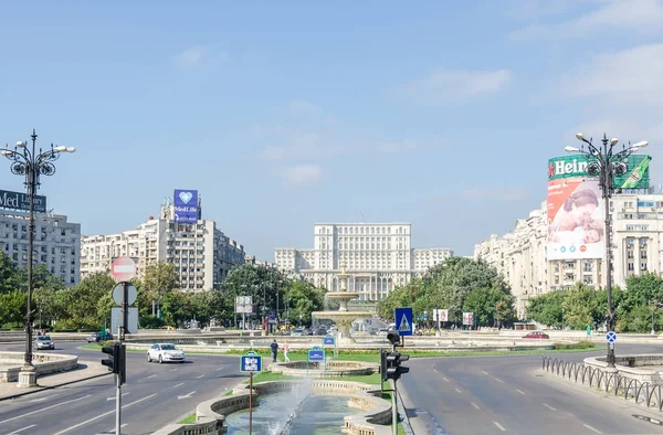 Plac "Piata Unirii" ze sklepów, ruchu samochodów, ludzi. Widok na dom ludowy. — Zdjęcie stockowe