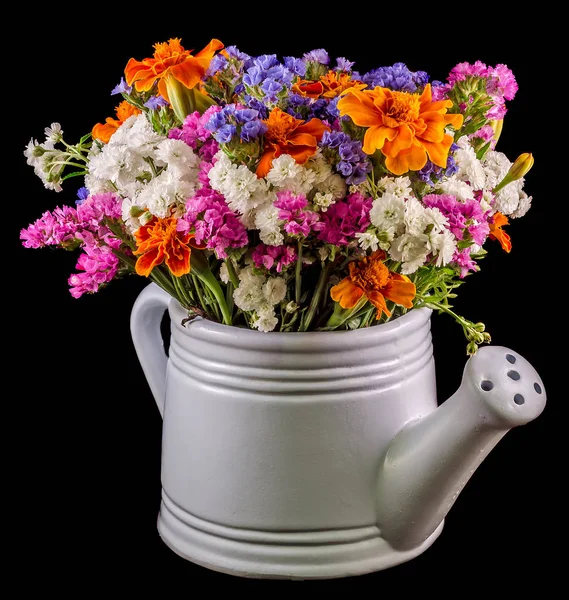 White ceramic watercan, sprinkler, with vivid colored flowers