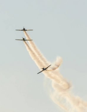 Şehrin gökyüzünde eğitim akrobasi uçak pilotları. İzleme duman ile renkli uçak.