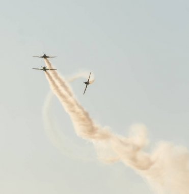 Şehrin gökyüzünde eğitim akrobasi uçak pilotları. İzleme duman ile renkli uçak.