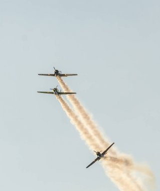 Şehrin gökyüzünde eğitim akrobasi uçak pilotları. İzleme duman ile renkli uçak.