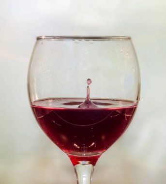 Şeffaf bir bardak kırmızı şarap bırak, yakın çekim.
