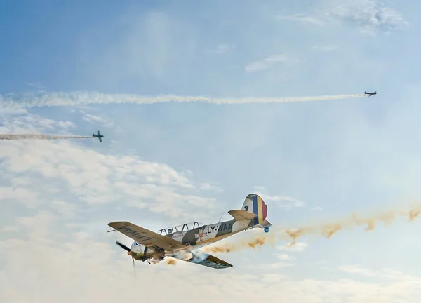 Pilotos de aviones acrobáticos entrenando en el cielo de la ciudad. Avión de color con rastro de humo . — Foto de Stock