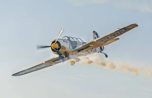 Pilotos de aviones acrobáticos entrenando en el cielo de la ciudad. Avión de color con rastro de humo . — Foto de Stock