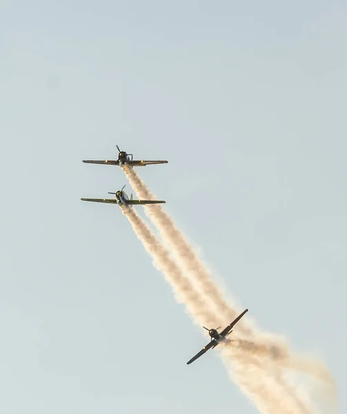 Pilotos de aviones acrobáticos entrenando en el cielo de la ciudad. Avión de color con rastro de humo . —  Fotos de Stock