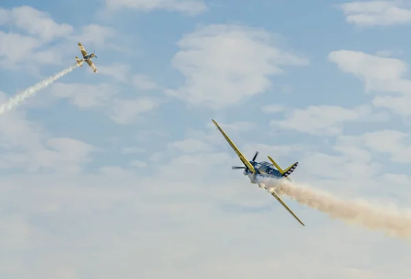 Aerobatic pilotos de avião de formação no céu da cidade. Avião colorido com traço de fumaça . — Fotografia de Stock