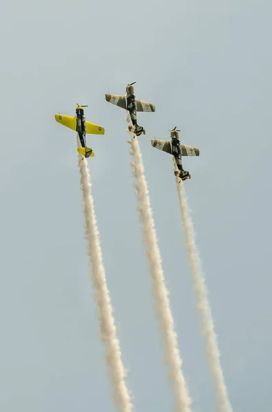 Şehrin gökyüzünde eğitim akrobasi uçak pilotları. İzleme duman ile renkli uçak. — Stok fotoğraf