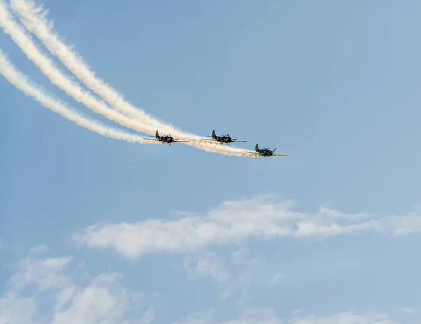 도시의 하늘에 훈련 비행 비행기 조종사. 추적 연기와 컬러 비행기. — 스톡 사진