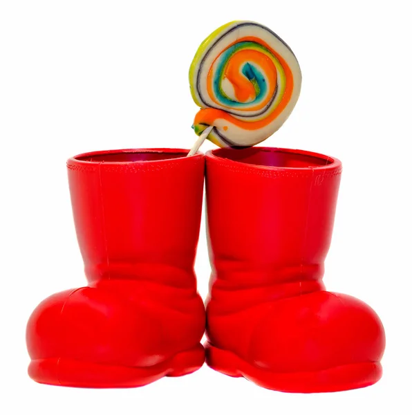 Botas rojas de Santa Claus, zapatos con piruletas dulces de colores, dulces — Foto de Stock