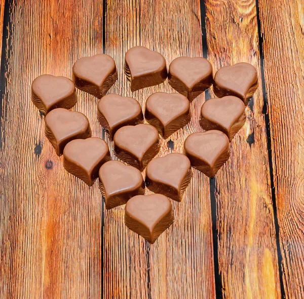 Herzförmige Schokolade, Valentinstag-Bonbons, braunes Holz-Backgro — Stockfoto