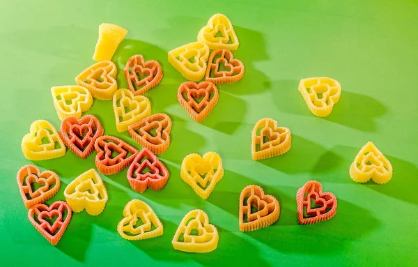 Red, yellow and orange heart shape pasta, close up, degraded — Stock Photo, Image