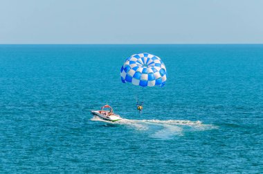 Mavi parasail kanat çekti bir tekne deniz suyu ile Parasailing