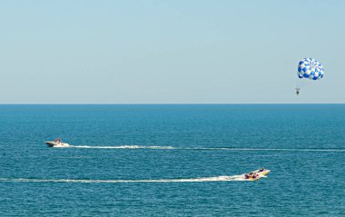 Mavi parasail kanat çekti bir tekne deniz suyu ile Parasailing