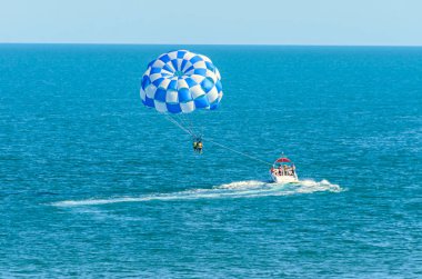 Mavi parasail kanat çekti bir tekne deniz suyu ile Parasailing