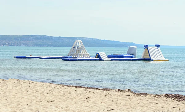 Голубая водная горка на морском пляже, детская площадка для игр и прыжков, крупный план — стоковое фото