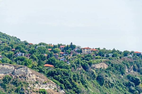 Evler, mavi bulutlar gökyüzü ile Karadeniz kıyı, yeşil tepeler.