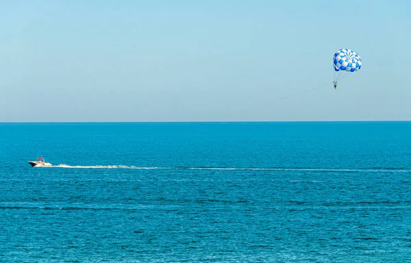 Ala de parasail azul tirado por un barco en el agua de mar, Parasailing —  Fotos de Stock