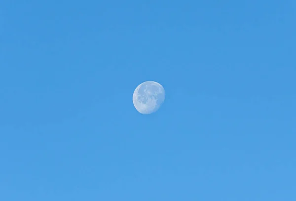 Белая луна в дневное время, голубое чистое небо, закрыть — стоковое фото