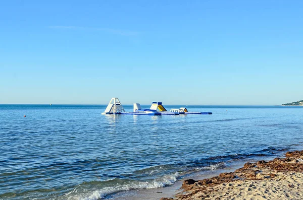 Water sport air slide on sea water near beach with sand