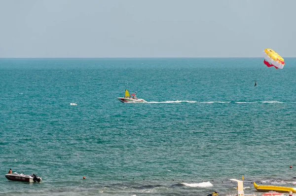 Farbige Parasail-Flügel von einem Boot im Meerwasser gezogen — Stockfoto