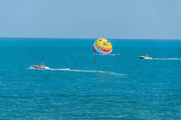 Цветное крыло парашютиста, вытащенное лодкой в морской воде — стоковое фото