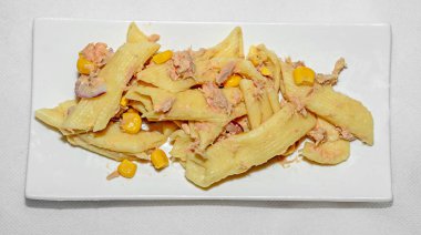 Kırmızı soğan, ton balığı ve Mısır, beyaz tabak izole ile pişmiş makarna