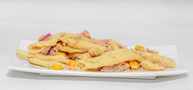 Kırmızı soğan, ton balığı ve Mısır, beyaz tabak izole ile pişmiş makarna