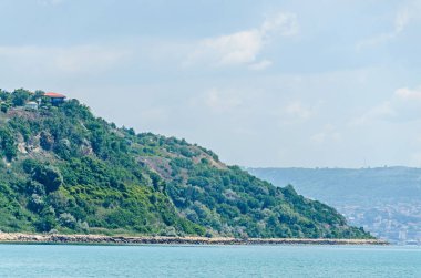 Evler, mavi bulutlar gökyüzü ile Karadeniz kıyı, yeşil tepeler. 