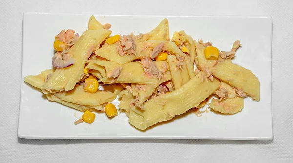 Kırmızı soğan, ton balığı ve Mısır, beyaz tabak izole ile pişmiş makarna