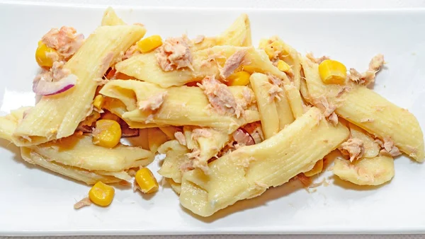 Kırmızı soğan, ton balığı ve Mısır, beyaz tabak izole ile pişmiş makarna