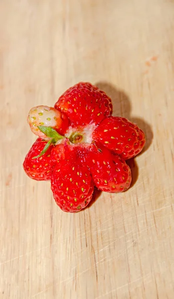 Stella a forma di frutta rossa fragola, fondo in legno rustico, primo piano — Foto Stock