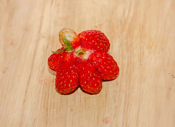 Stella a forma di frutta rossa fragola, fondo in legno rustico, primo piano — Foto Stock