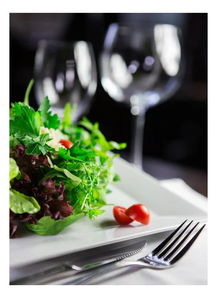 Sałatka z pomidorów i świec światła w restauracji wyśmienitą — Zdjęcie stockowe