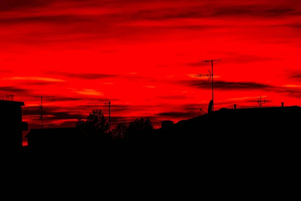 Червоне небо на заході сонця над дахами Болоньї — стокове фото