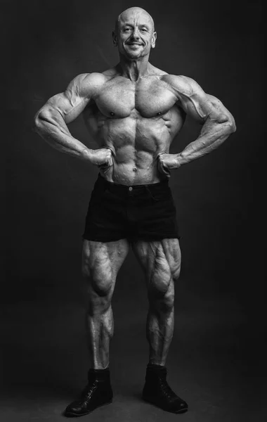 Atleta in posa diffusione lat anteriore. Culturista mostrando muscoli su sfondo studio — Foto Stock