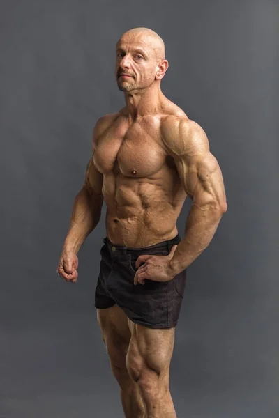 Professijnal kulturista a fitnes model představuje hrudník, biceps a šest pack abs. — Stock fotografie