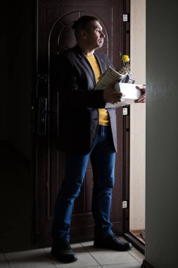 Kovulmak. Eşyalarıyla birlikte bir kutu tutan adam..