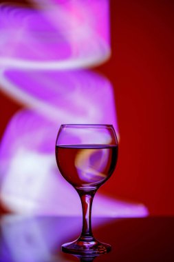 Güzel, kırmızı bir arka planda içkisi olan bir bardak.