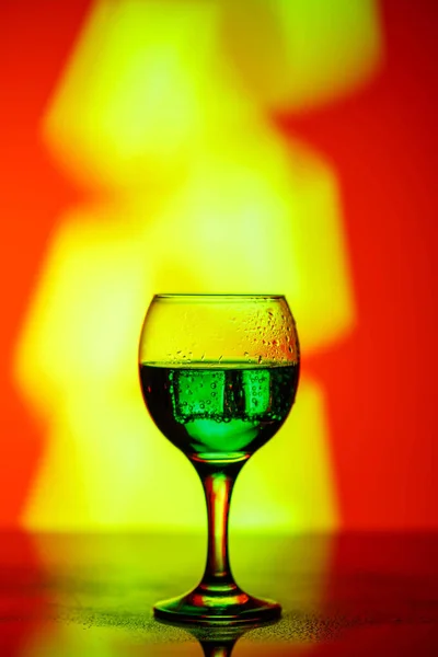 A glass with a drink on a beautiful red background illuminated w — ストック写真